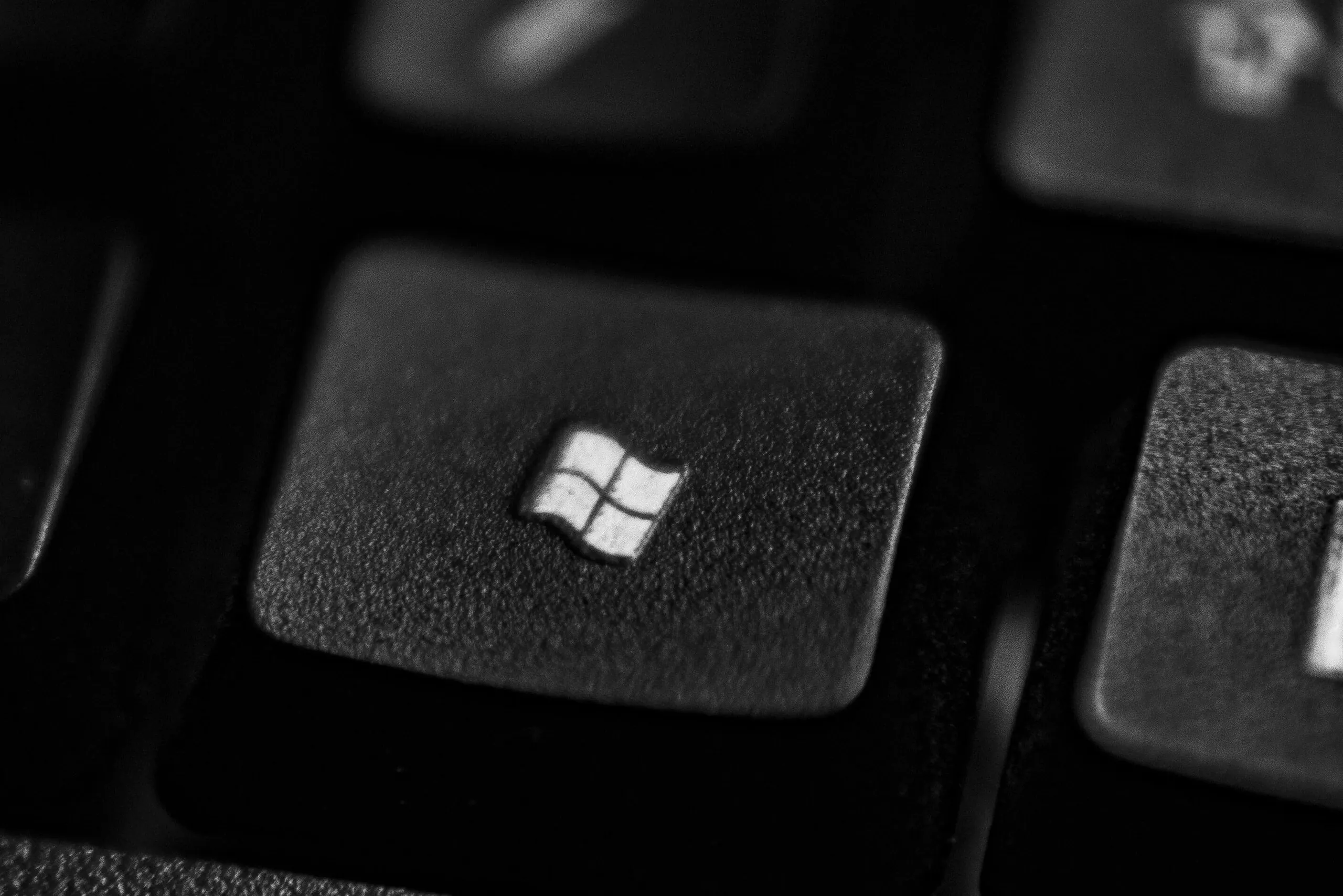 High-quality close-up of a Windows logo key on a black plastic keyboard.